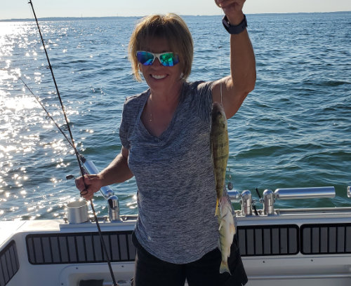 Woman showing off perch caught on Charter Trip
